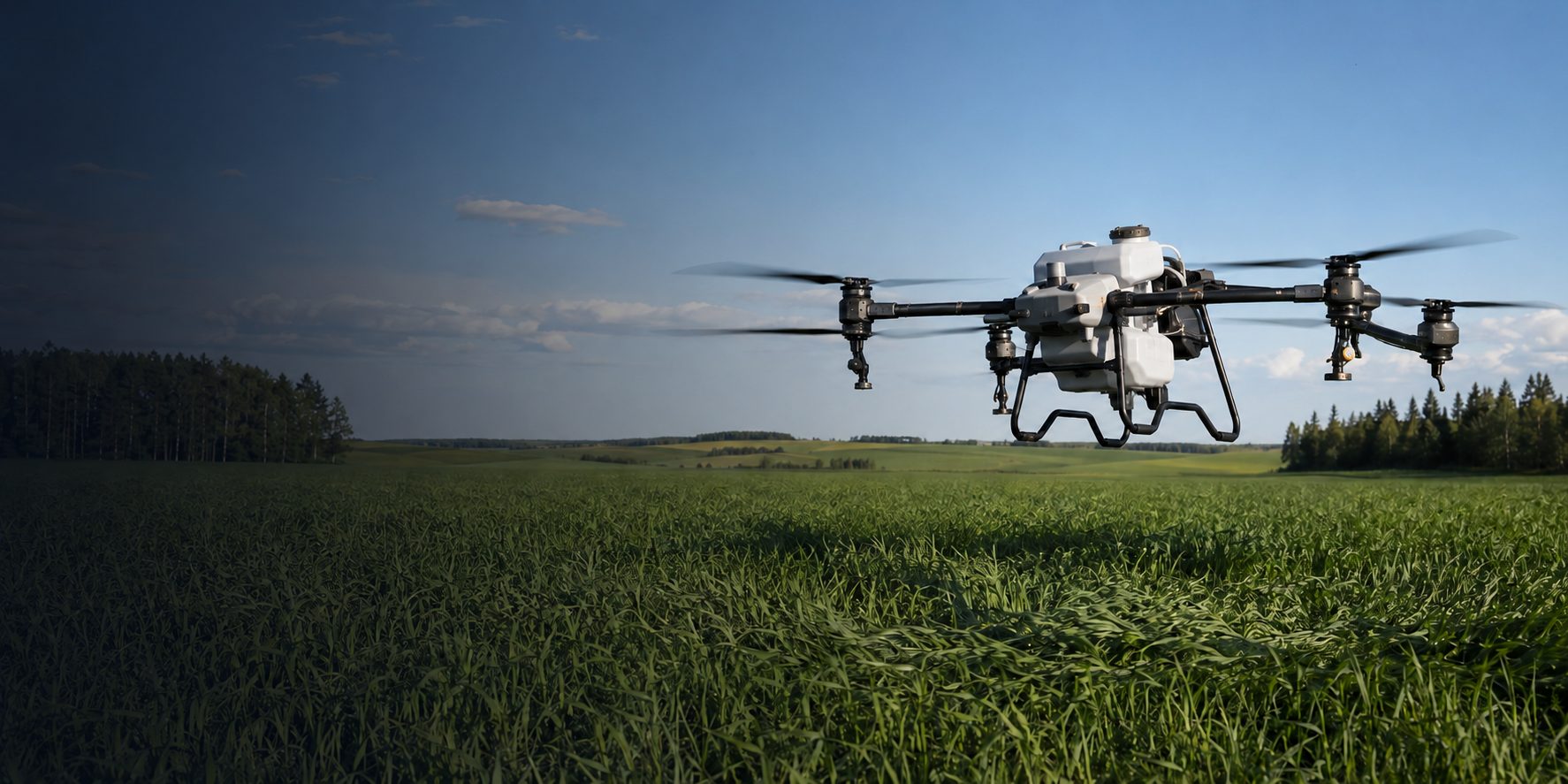 Agricultural spray drone hovering low over a green Alberta field